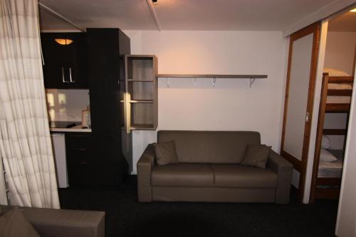 un salon avec un canapé et une cuisine dans l'établissement Résidence Eskival - ESKIVAL APPARTEMENT 35M² 4 PERS CENTRE STATION ACCES DIRECT SUR LES PISTES MAE-7584, à Val Thorens
