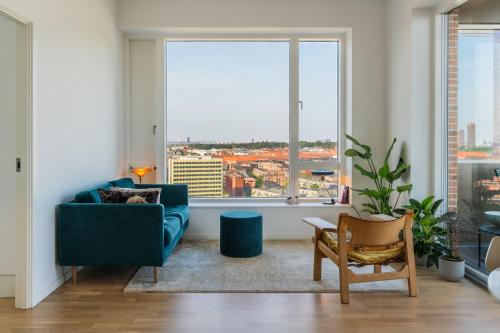 a living room with a blue couch and a large window at View from the 18th floor over whole of Copenhagen. in Copenhagen