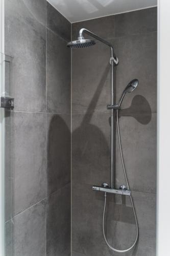 a shower with a shower head in a bathroom at View from the 18th floor over whole of Copenhagen. in Copenhagen
