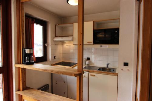 une petite cuisine avec des armoires blanches et un évier dans l'établissement Résidence Eskival - ESKIVAL APPARTEMENT 35M² 4 PERS CENTRE STATION ACCES DIRECT SUR LES PISTES MAE-7590, à Val Thorens