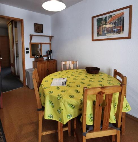 une table à manger avec un chiffon jaune dans l'établissement Résidence Eskival - 2 Pièces pour 4 Personnes 92, à Val Thorens
