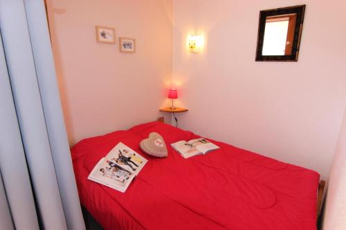 - un lit rouge dans une petite chambre avec une couverture rouge dans l'établissement Résidence Cimes De Caron - CIMES DE CARON STUDIO CABINE 24M² 4 PERS MAE-7601, à Val Thorens