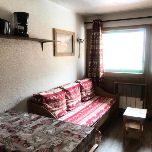 une chambre avec un lit avec des oreillers et une fenêtre dans l'établissement Résidence Vanoise - STYLE MONTAGNE POUR CE 2 PIECES POUR 4 PERSONNES EN CENTRE STATION MAE-7604, à Val Thorens