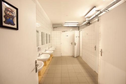bagno con 4 lavandini e una fila di servizi igienici di Le Flâneur Guesthouse a Lione