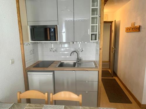une petite cuisine avec un évier et un micro-ondes dans l'établissement Résidence Lauzieres - JOLI 2 PIECES CABINE POUR 4 PERSONNES QUARTIER SOLEIL MAE-7613, à Val Thorens