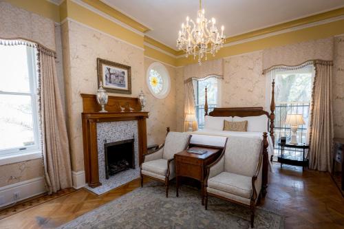 a bedroom with a bed and a desk and a fireplace at The Gastonian, Historic Inns of Savannah Collection in Savannah