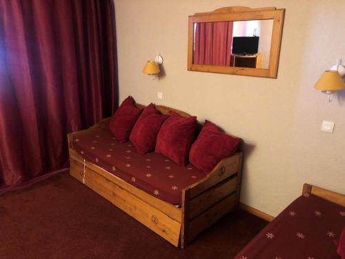 - un lit avec des oreillers rouges dans une chambre d'hôtel dans l'établissement Résidence Temples Du Soleil Cuzco - TEMPLES DU SOLEIL CUZCO STUDIO CABINE 23M² 4 PERS FONCTIONNEL PIED DES PISTES MAE-7619, à Val Thorens