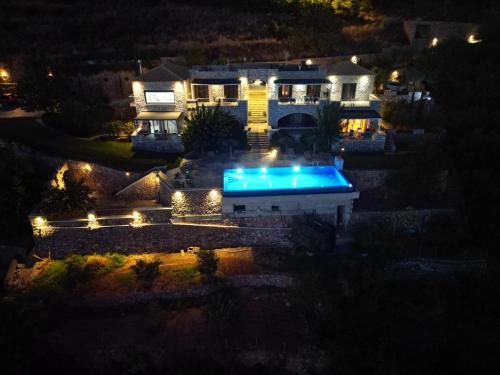 a house with a swimming pool at night at Petra Thea in Kalamata