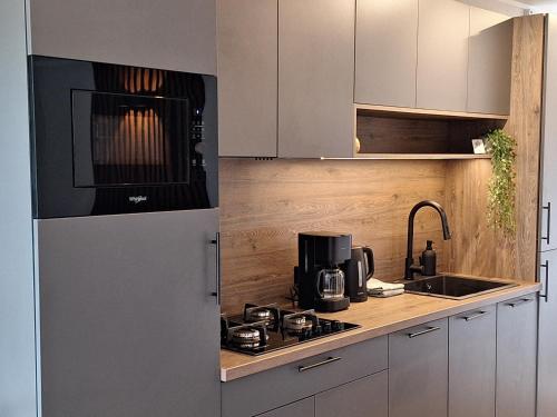a kitchen with a white refrigerator and a sink at 'Relax Lodge Sea' - Wellness lodge in Zeeland - Private Sauna - Airco - Garden - Outdoor Swimming pool - Free Wifi, Towels & Bed linen in Heinkensand