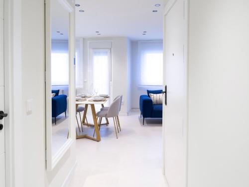 a dining room with a table and chairs and a mirror at Loft América 32 in Melide