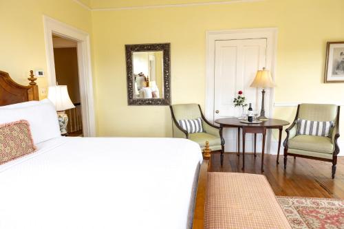 a bedroom with a bed and a table and chairs at The Gastonian, Historic Inns of Savannah Collection in Savannah