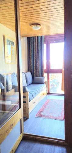 un salon avec un canapé et une fenêtre dans l'établissement Résidence Eskival - ESKIVAL APPARTEMENT 35M² 4 PERS CENTRE STATION ACCES DIRECT SUR LES PISTES MAE-7662, à Val Thorens