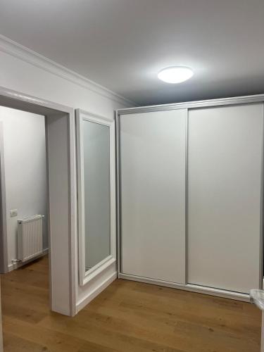 an empty room with sliding glass doors and wood floors at PremiumSuites in Giurgiu