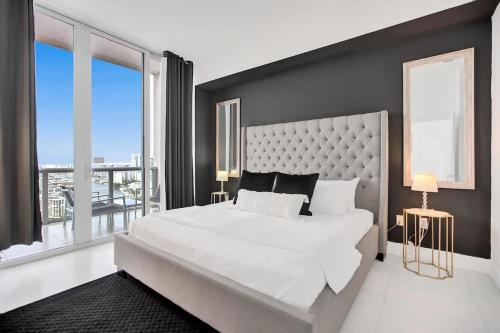 a bedroom with a large white bed with a large window at Penthouse Sky Suite - 2BDR2BTH - Private Rooftop Terrace in Hallandale Beach