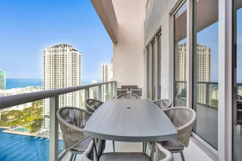 a table and chairs on a balcony with a view of the ocean at Penthouse Sky Suite - 2BDR2BTH - Private Rooftop Terrace in Hallandale Beach