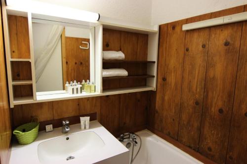 une salle de bain avec un lavabo, un miroir et une baignoire dans l'établissement Résidence Temples Du Soleil Machu - VAL THORENS 2 PIECES 4 PERSONNES AU PIED DES PISTES ET EXPOSE SUD MAE-7683, à Val Thorens