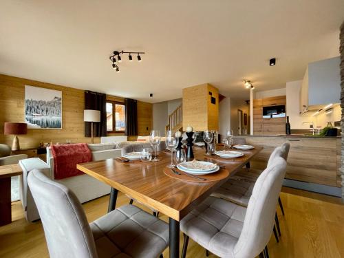 une salle à manger avec une table et des chaises en bois dans l'établissement Homency - Résidence Fermes de l'Alpe A301, à L'Alpe-d'Huez