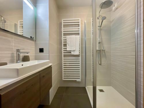 une salle de bain blanche avec un lavabo et une douche dans l'établissement Homency - Résidence Fermes de l'Alpe A301, à L'Alpe-d'Huez