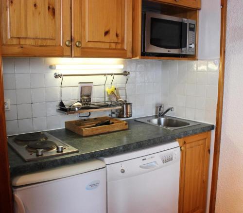 une petite cuisine avec un évier et un micro-ondes dans l'établissement Résidence Orciere - VAL THORENS AGREABLE 2 PIECES POUR 4 PERSONNES ORIENTE SUD ET PIED DES PISTES MAE-7698, à Val Thorens