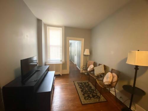 a living room with a couch and a television at Clover 2900 - Apartment and Rooms with Private Bathroom near Washington Ave South Philly in Philadelphia
