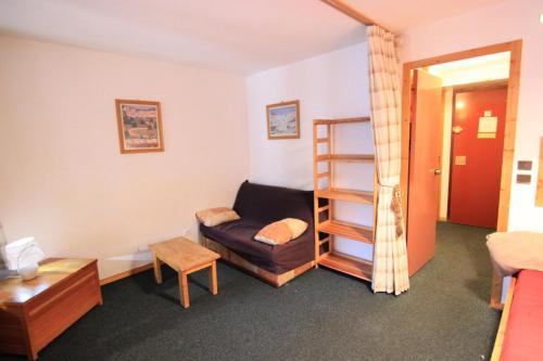 - un salon avec un canapé et une étagère dans l'établissement Résidence Eskival - ESKIVAL APPARTEMENT 35M² 4 PERS CENTRE STATION ACCES DIRECT SUR LES PISTES MAE-7711, à Val Thorens