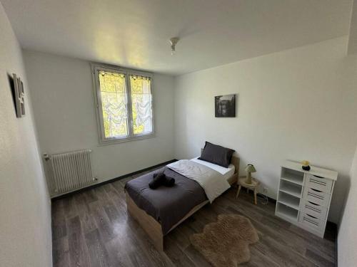 une chambre avec un lit sur lequel est allongé un chat dans l'établissement Appartement T3 64m2 avec Balcon, vue sur le centre historique, WI-FI et PARKING GRATUIT, au Puy-en-Velay