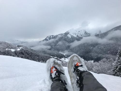 a person with their feet up on a snow covered mountain at Suite Romantica Fuga in Roncone