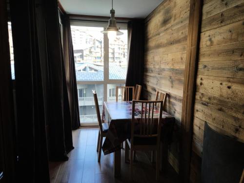 a dining room with a table and chairs and a window at Résidence Eskival - ESKIVAL APPARTEMENT 35M² 4 PERS CENTRE STATION ACCES DIRECT SUR LES PISTES MAE-7721 in Val Thorens