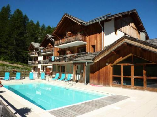 une maison avec piscine devant un immeuble dans l'établissement Residence La Combe D Or - Appartement 2 pièces 6 personnes en résidence de standing MAE-3651, aux Orres