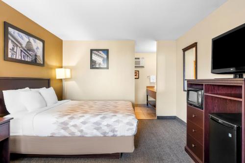 a hotel room with a bed and a flat screen tv at Americas Best Value Inn Yakima in Union Gap