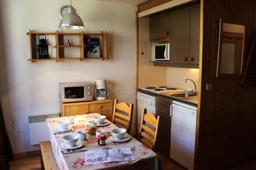 une petite cuisine avec une table et une table et des chaises dans l'établissement Résidence Orciere - 2 PIECES CABINE POUR 4 PERSONNES AVEC BALCON MAE-7747, à Val Thorens
