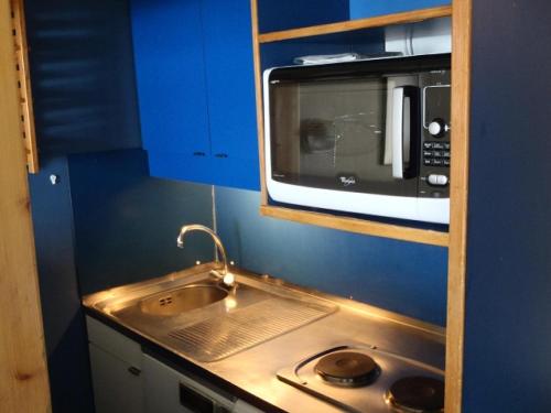 une petite cuisine avec un évier et un micro-ondes dans l'établissement Résidence Temples Du Soleil Machu - VAL THORENS 2 PIECES 4 PERSONNES EXPOSE SUD ET AU PIED DES PISTES MAE-7744, à Val Thorens