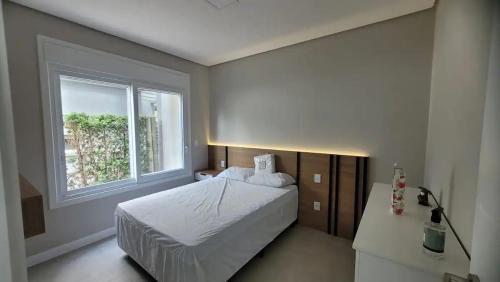 une chambre avec un lit et une fenêtre dans l'établissement Verão Relaxante no Condomínio Las Palmas, à Xangri-lá