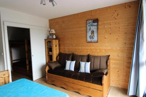 - un canapé en cuir dans une chambre dotée d'un mur en bois dans l'établissement Résidence Lac Du Lou - VAL THORENS CHARMANT STUDIO POUR 3 PERSONNES EXPOSE SUD MAE-7749, à Val Thorens
