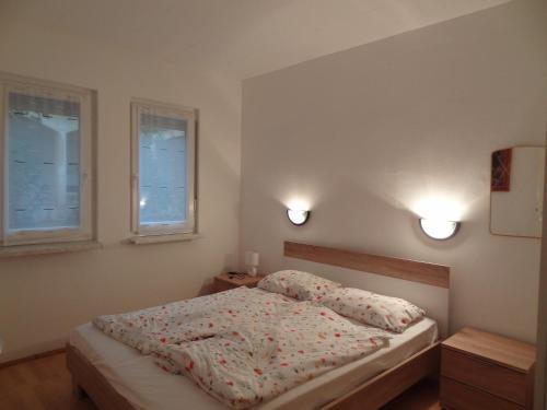 a bedroom with a bed and two windows at Tuan Vir Apartment in Vir