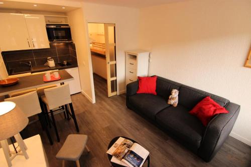 un salon avec un canapé et une cuisine dans l'établissement Résidence Hauts De Chaviere - HAUTS DE CHAVIERE STUDIO 23M² 4PERS PLACE SLALOM DECO MODERNE MAE-7756, à Val Thorens