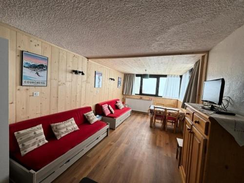un salon avec un canapé rouge et une télévision dans l'établissement Résidence Trois Vallees - Studio pour 3 personnes à proximité des commerces . MAE-7764, à Val Thorens
