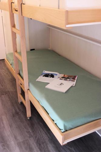 - un lit superposé en bas avec un livre dans l'établissement Résidence Hauts De Chaviere - HAUTS DE CHAVIERE STUDIO 23M² 4PERS PLACE SLALOM DECO MODERNE MAE-7756, à Val Thorens