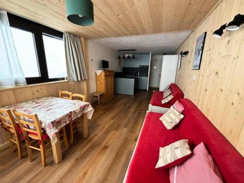un salon avec un canapé rouge et une table dans l'établissement Résidence Trois Vallees - Studio pour 3 personnes à proximité des commerces . MAE-7764, à Val Thorens