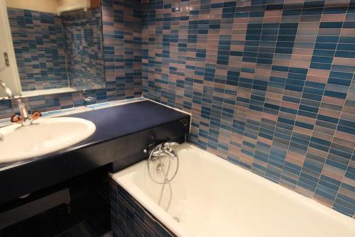 une salle de bain avec une baignoire et un lavabo et une baignoire dans l'établissement Résidence Trois Vallees - STUDIO 3 PERSONNES A 2 PAS DU CENTRE QUARTIER PECLET MAE-7761, à Val Thorens