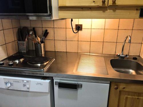 une cuisine avec un évier et un plan de travail dans l'établissement Résidence Gollet - Le Gollet 63 - Studio divisible MAE-5781, à Valmorel