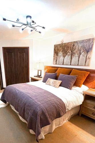 a bedroom with a large bed and a painting on the wall at Luxury Auberge Madeline Residence Building in Telluride