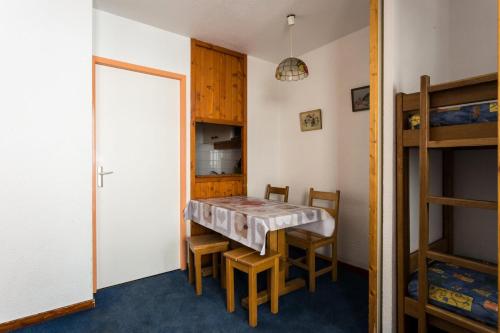 une chambre avec une table, des chaises et des lits superposés dans l'établissement Résidence Zenith - DEPART ET RETOUR SKIS AUX PIEDS EXPOSE SUD STUDIO POUR 3 PERSONNES MAE-7767, à Val Thorens