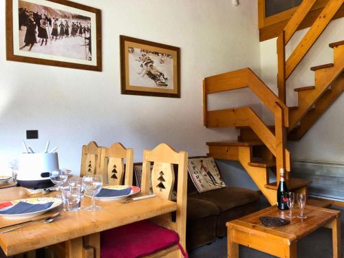 une salle à manger avec une table et un escalier dans l'établissement Résidence Cotes - Les Côtes 26 - Appartement duplex et traversant avec ses deux balcons. MAE-5791, à Valmorel