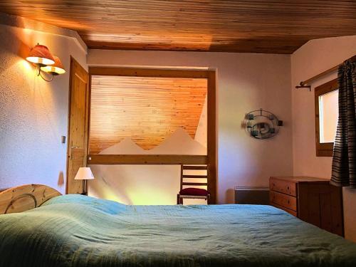 une chambre avec un lit et un plafond en bois dans l'établissement Résidence Cotes - Les Côtes 26 - Appartement duplex et traversant avec ses deux balcons. MAE-5791, à Valmorel