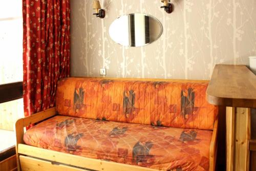 - un canapé dans le salon avec un miroir dans l'établissement Résidence Serac - CHARMANT STUDIO POUR 3 PERSONNES BIEN EQUIPE AVEC BALCON EXPOSE SUD MAE-7774, à Val Thorens