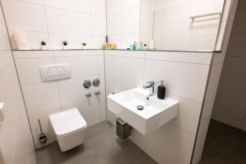 Munich Large Apartment 110 qm, 3 Bedrooms and very Central 1-12 Guests في ميونخ: حمام أبيض مع حوض ومرحاض