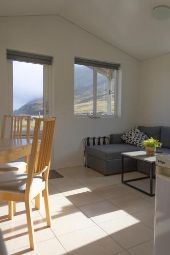 a living room with a table and a couch at Urdartindur Guesthouse and Cottages in Norðurfjörður