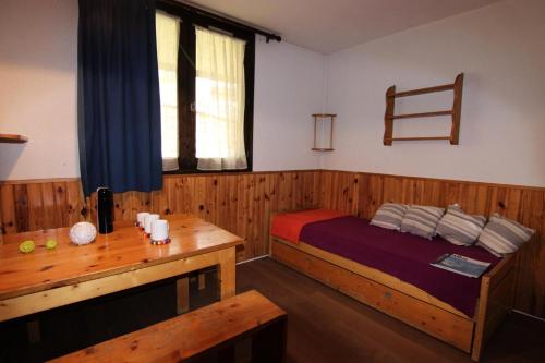 een slaapkamer met een bed en een houten tafel bij Résidence Roche Blanche - VAL THORENS STUDIO 2 PERSONNES CENTRAL MAE-7793 in Val Thorens