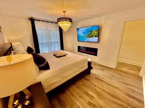 a bedroom with a large bed and a flat screen tv at Luxury City Loft in Gainesville B in Gainesville